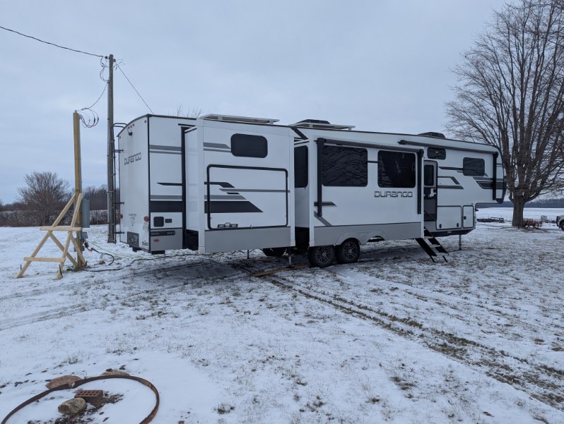 RV winterized and set up in snow for winter living on a homeowner's property